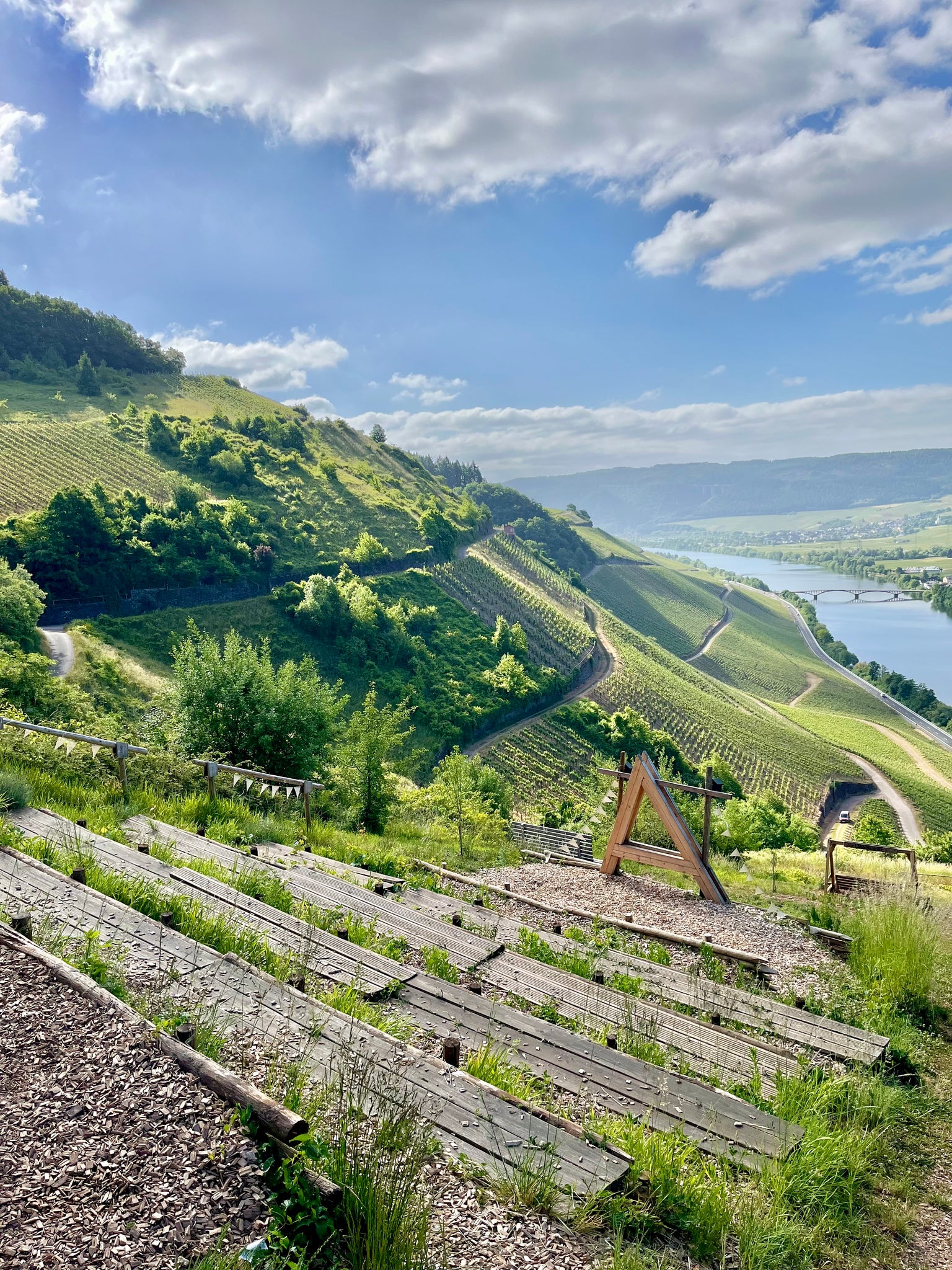 Aussichtspunkt Lagenliebe oberhalb von Schweich – terrassenartige Sitzstufen und Holzschaukeln inmitten der steilen Moselweinberge mit Panoramablick über das Moseltal und die Rebhänge
